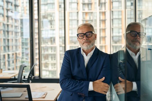 Accomplished businessman posing confidently at well-designed office Accomplished businessman posing confidently at well-designed office